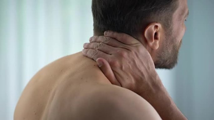男性触摸颈部，感觉上背部痉挛强烈，神经受压，不适