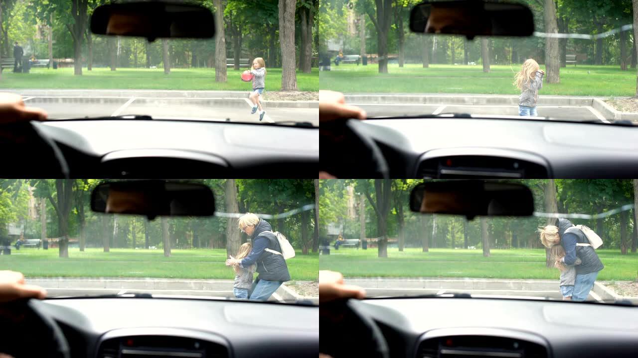 驾驶员在道路上玩耍的注意力不集中的孩子的前面停下来，父母拥抱孩子