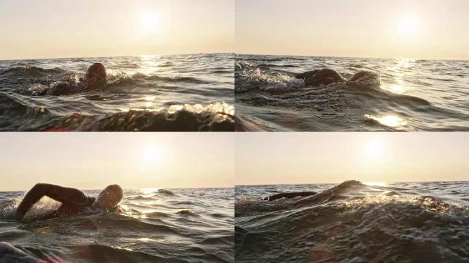 SLO MO TS男性公开水域游泳者在阳光下波涛汹涌的大海游泳