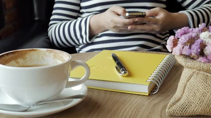 年轻女子在休闲时间在咖啡厅使用智能手机