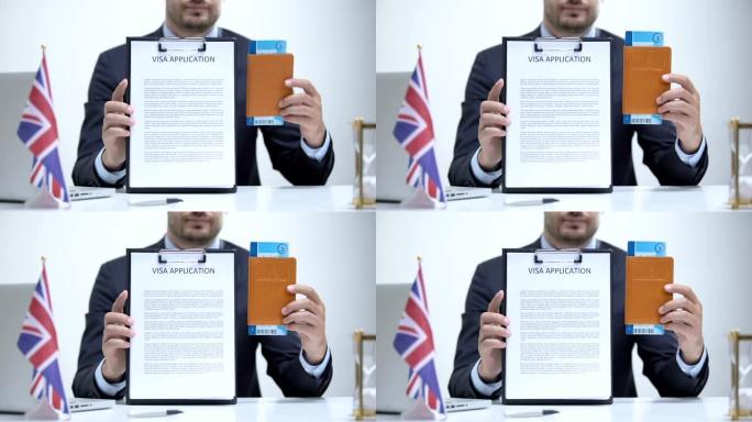 英国领事官员持有签证申请和护照，游客面试