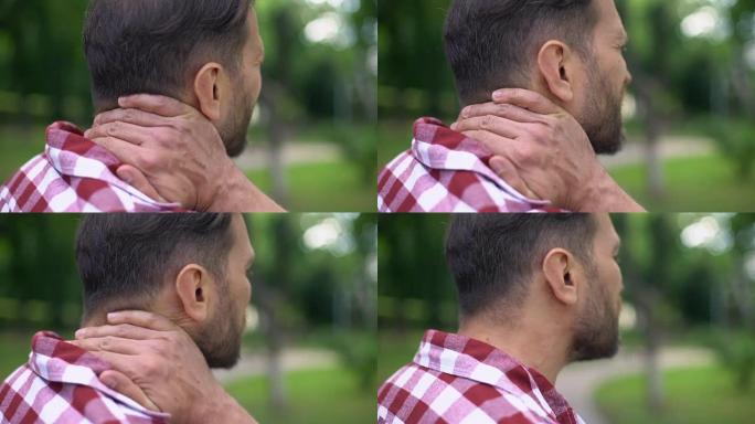 患病男性触摸颈部，患有强烈痉挛，脊柱不适，疼痛