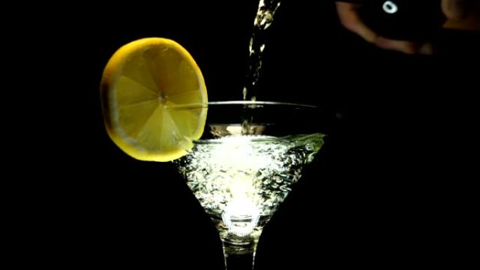 一名男子将马提尼酒 (白葡萄酒) 从瓶子倒入玻璃杯中