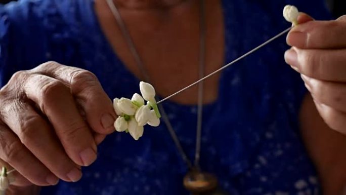 亚洲老年妇女制作茉莉花环