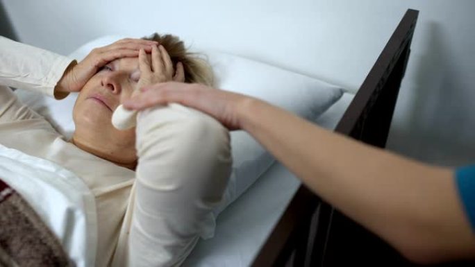 护士在医院对女性患者的额头进行压缩，医疗保健