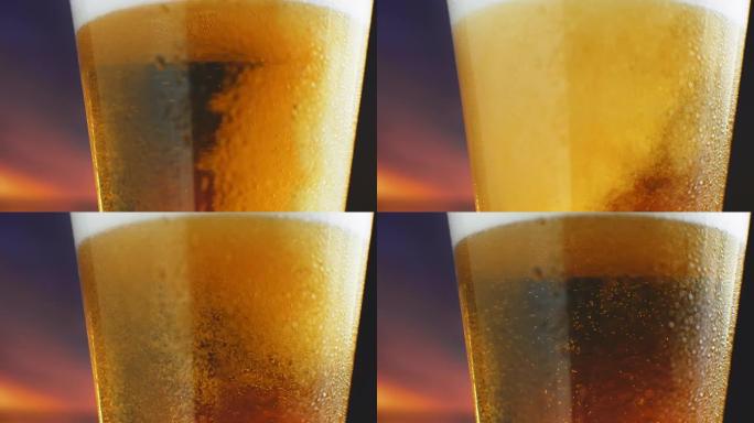 慢动作宏观冰镇啤酒被倒入带有汗水的玻璃杯中。啤酒气泡上升到表面
