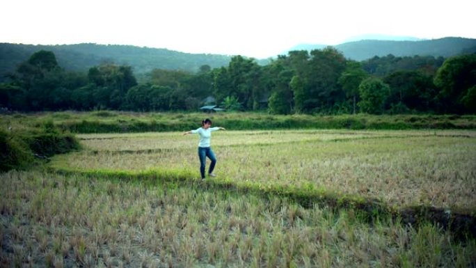 女人感觉享受和走在稻田里