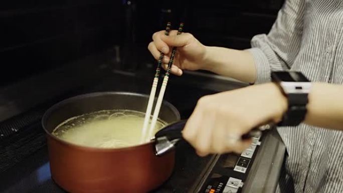 女人搅拌面条煮面煮米线做饭