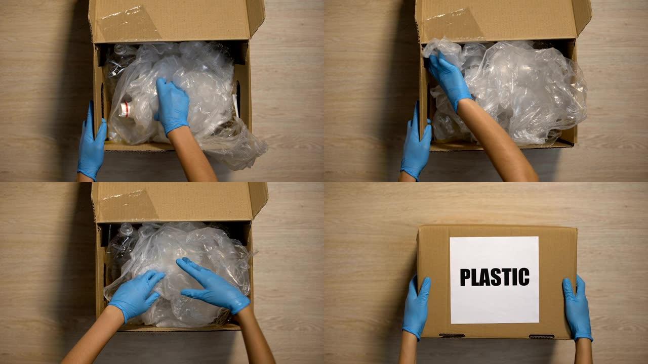 戴手套的下车站志愿者接受盒子里的塑料垃圾，重复使用