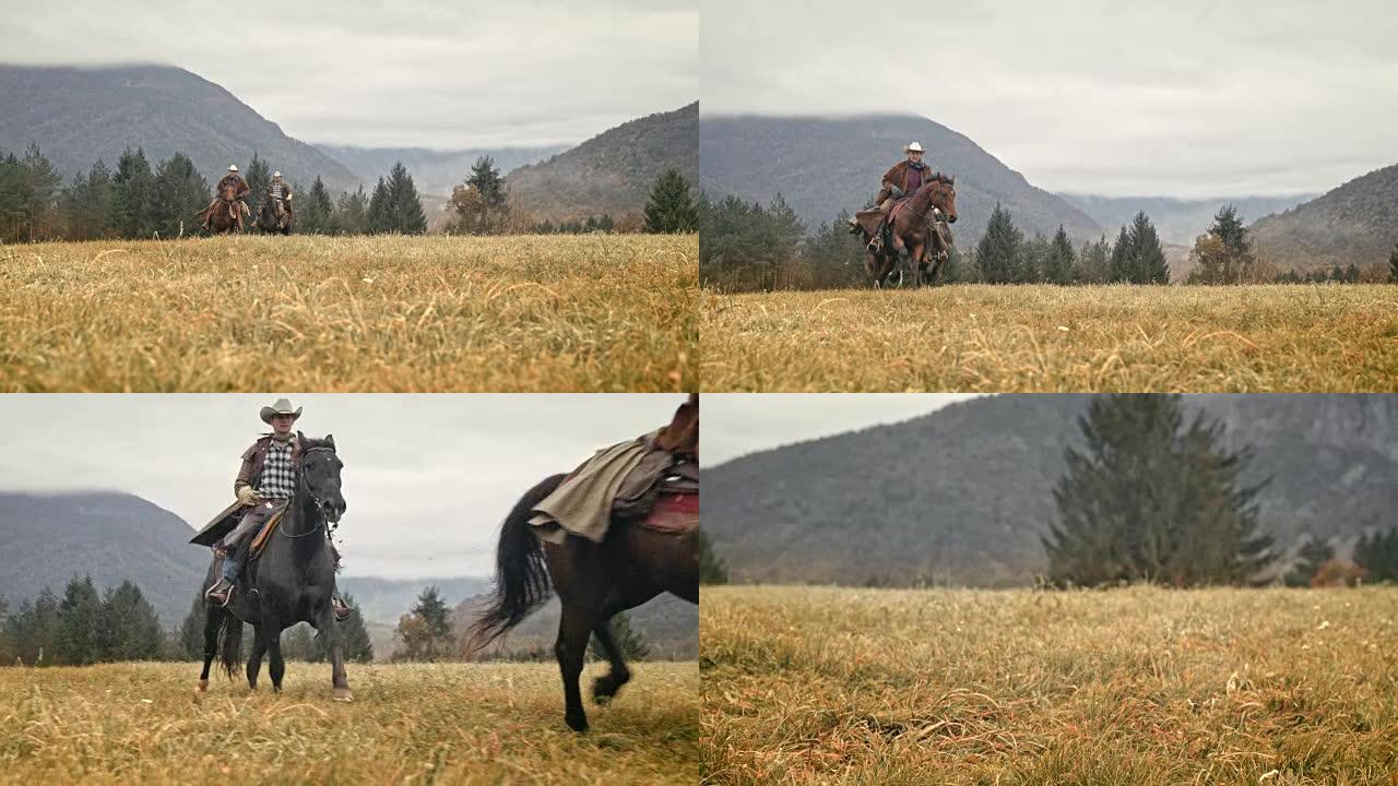 SLO MO两名牛仔在山上骑着奔腾的马