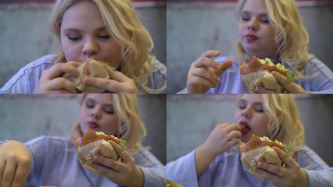 快餐成瘾者咀嚼油腻汉堡年轻女子有压力饮食障碍