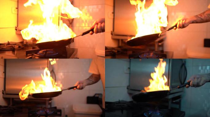 厨师在商用厨房中用平底锅准备火焰餐