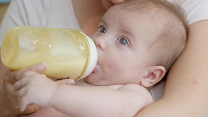 母亲奶瓶喂养她的婴儿