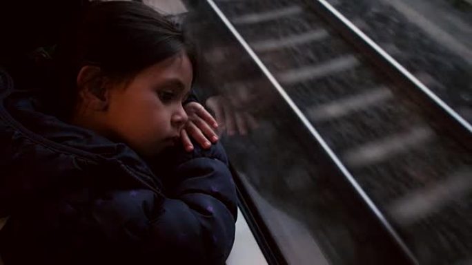 小女孩坐火车在窗外看。