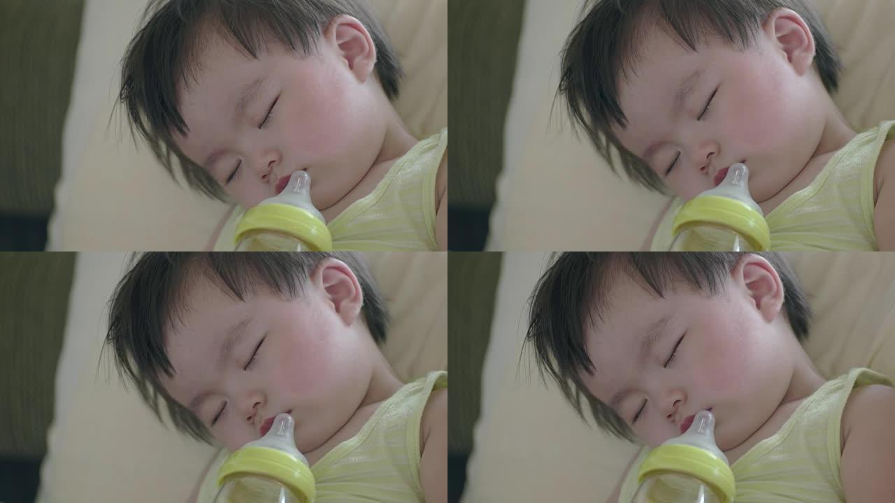 日本婴儿一边喝牛奶一边睡觉。侧视图。
