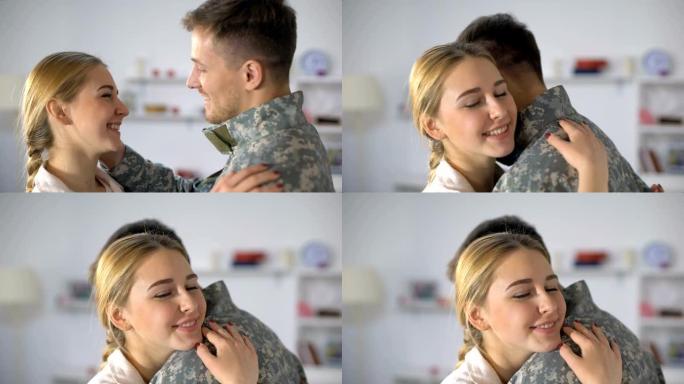 幸福的妻子拥抱穿着制服的男兵，服兵役后回家