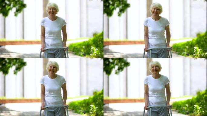开朗的老年女性，步行框架在户外看着相机，康复