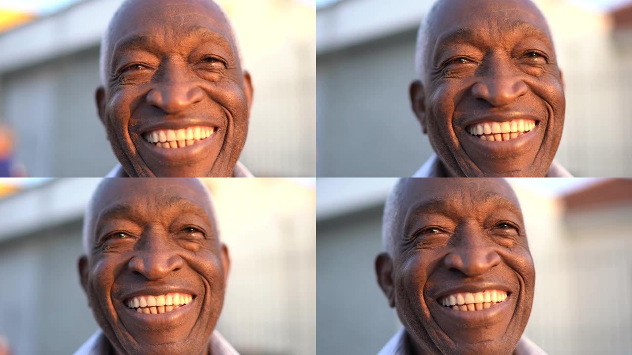 微笑的非洲男子在街上看着相机的肖像