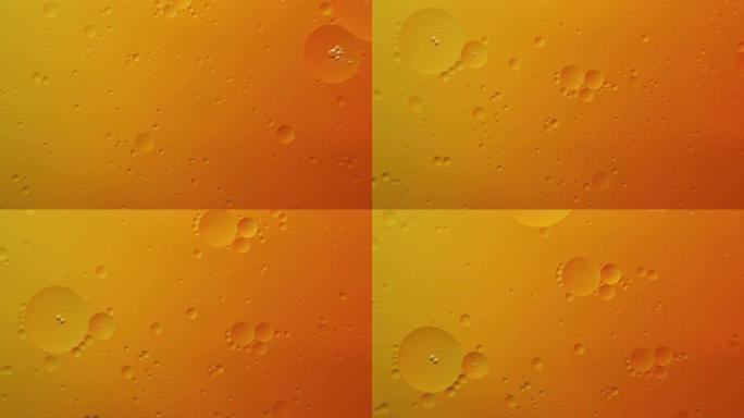 橙色背景上的油泡宏观摄影