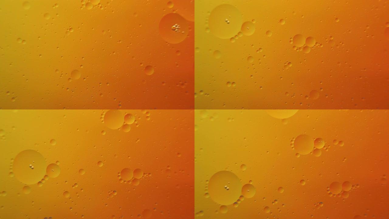 橙色背景上的油泡宏观摄影