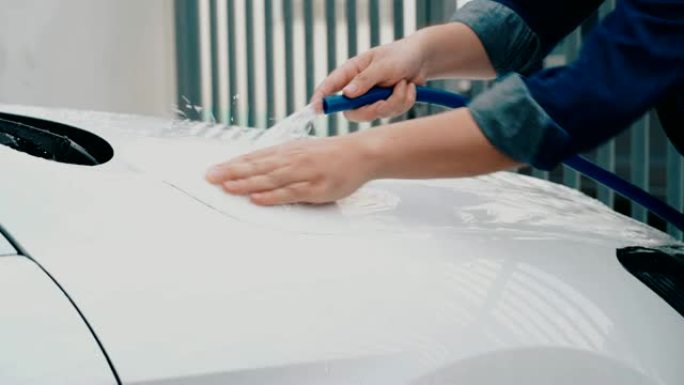 男人在洗一辆白色汽车。