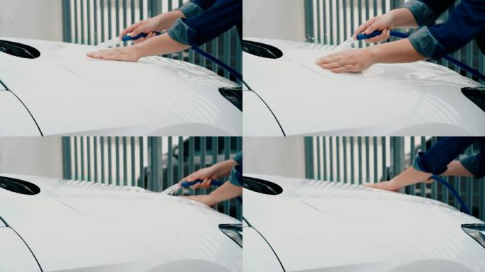 男人在洗一辆白色汽车。