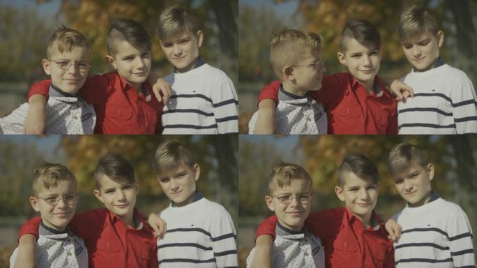 三个小男孩在户外微笑拥抱。兄弟们在一起。