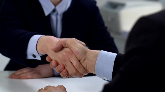 商业男女握手特写，交易合作伙伴关系联盟