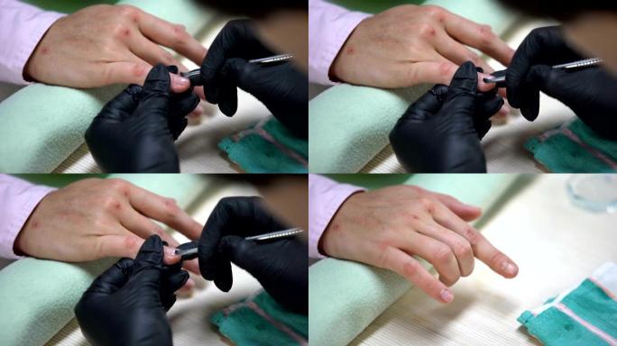指甲艺术家在手套去除指甲角质层，美容院程序，水疗