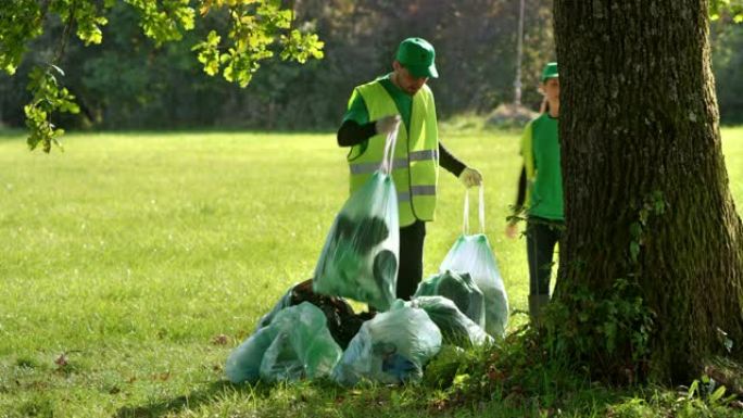 当地环境组织成员在当地清理活动后拿走垃圾袋