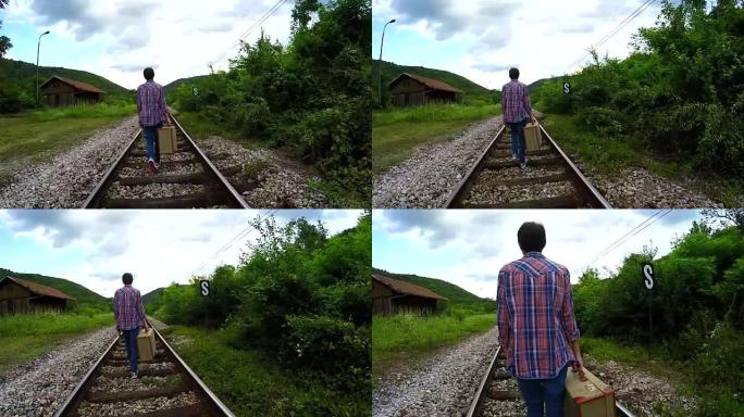 站在铁路上的复古手提箱的男人