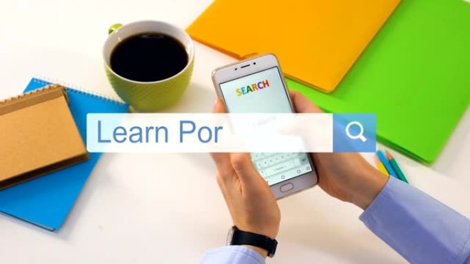 在智能手机搜索栏上打字的人学习葡萄牙语短语，教育