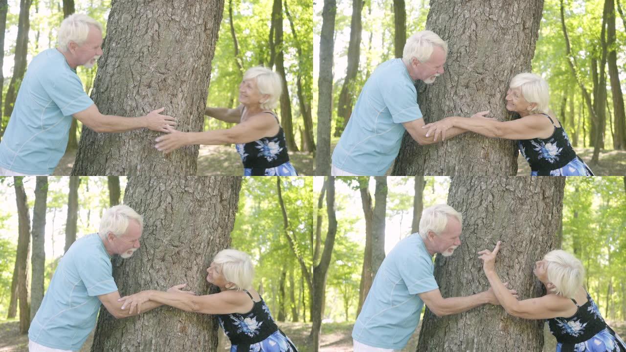幸福的成熟夫妇拥抱着茂密的树，互相抚摸着对方的手。