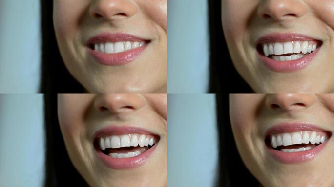 美丽的女人用完美的牙齿微笑的特写