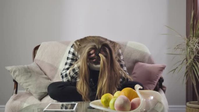 沮丧的白人女孩坐在沙发上用手握着头。压力少年有问题的肖像。青春期，过渡年龄。电影院4k ProRes