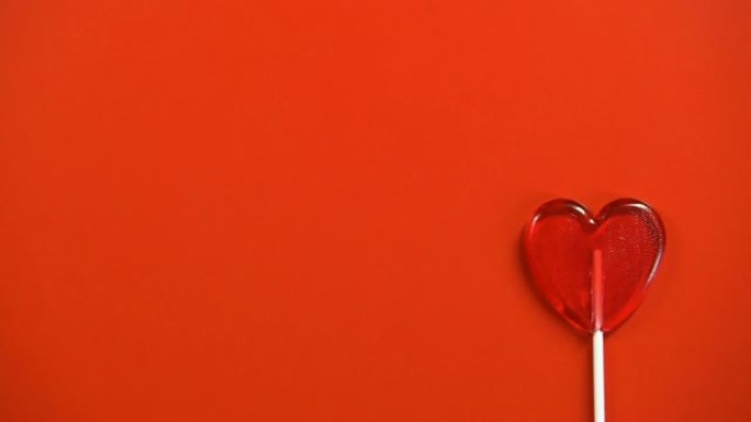 心形棒棒糖隔离在红色背景上，情人节庆祝活动