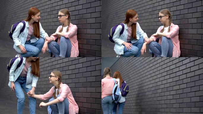 有爱心的女少年支持孤独的同学坐在一边，提供帮助
