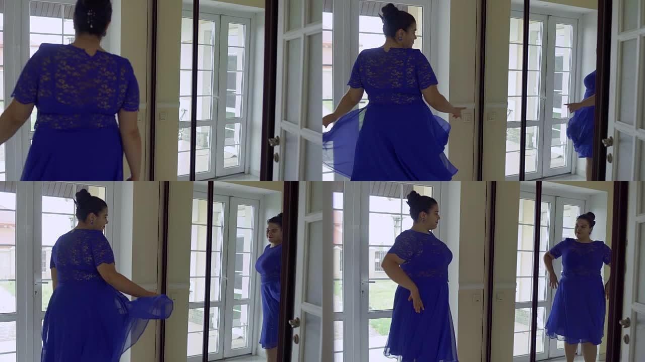 穿着蓝色连衣裙的胖女孩在镜子前