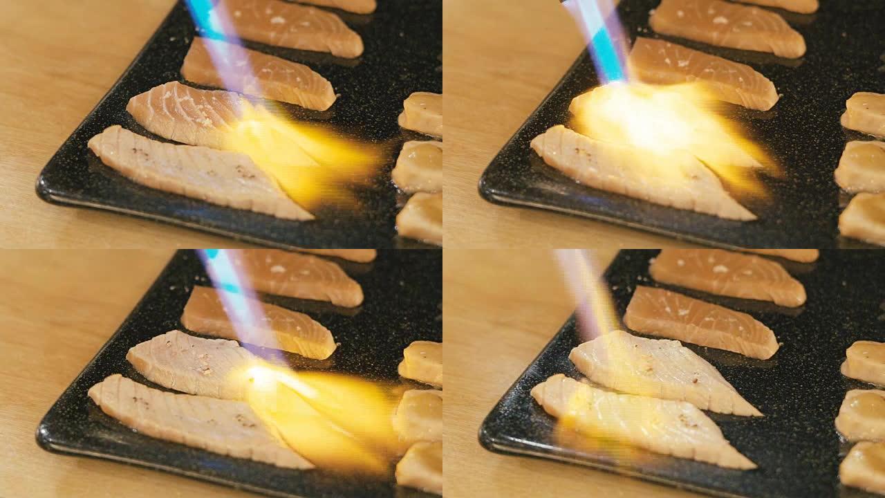 厨师用火炬烧鲑鱼寿司。