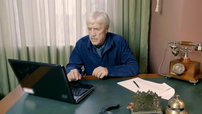 一名男子在办公室舒适的桌子上的笔记本电脑后面工作