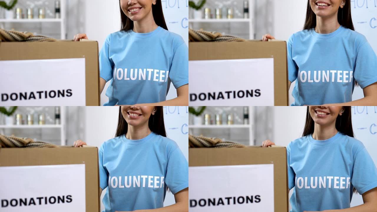 微笑的志愿者站在箱子旁，带着捐赠的衣服，无家可归的援助