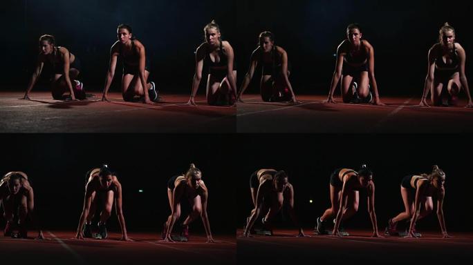晚上在跑步机上的三名运动女孩运动员在距坐姿的冲刺距离处开始比赛