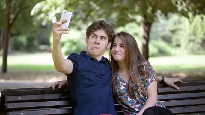 年轻夫妇在公园休息并使用智能手机