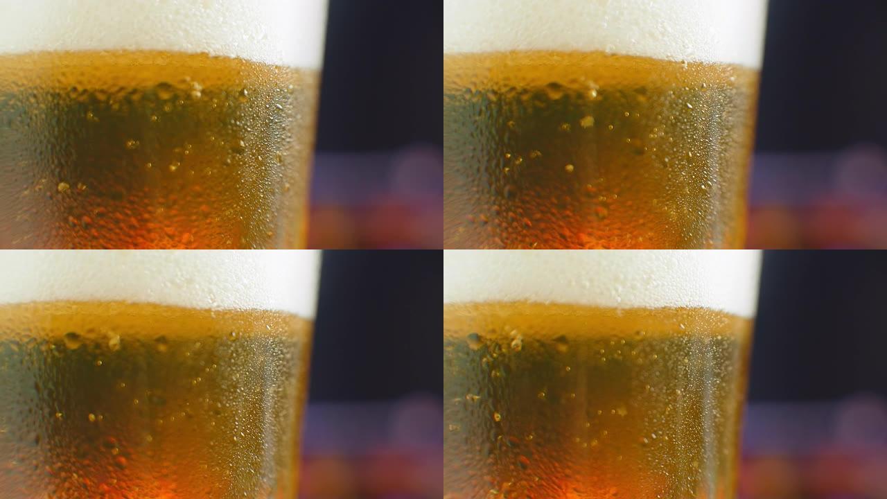 啤酒特写。一品脱冷精酿啤酒在哑光黑色背景上隔离，旋转360度。一杯带水滴的啤酒