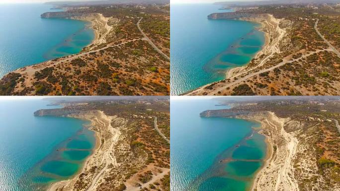 绿松石色海水上方的沙质悬崖。塞浦路斯。空中无人机射击。