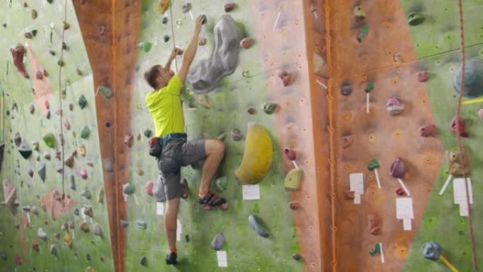 攀岩运动的概念: 墙上的人攀岩者。室内攀岩运动概念: 人工攀岩墙上的攀岩者
