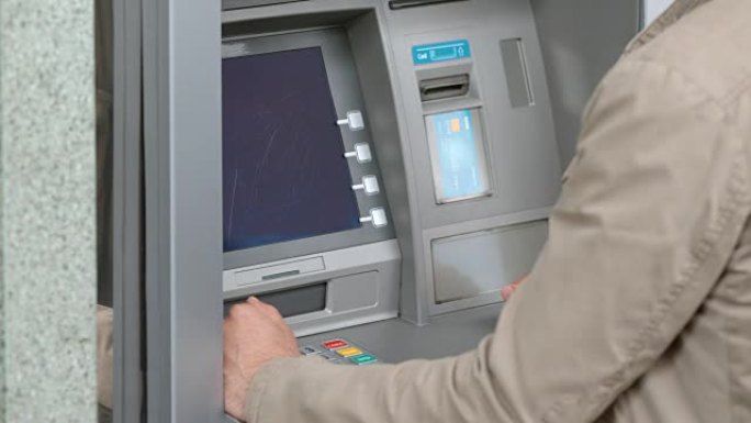 LD男子将银行卡插入自动柜员机的读卡器插槽，并输入他的个人识别码