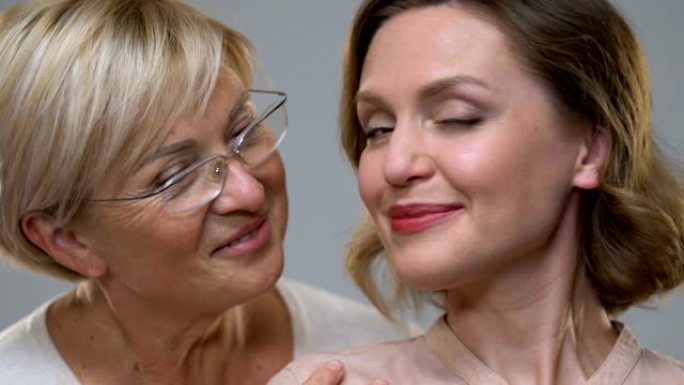 两个不同年龄的女人在镜头前微笑，年龄变化的护肤，特写镜头