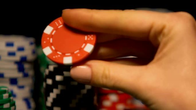 女士手中转动着扑克牌筹码，琢磨着游戏的策略、运势