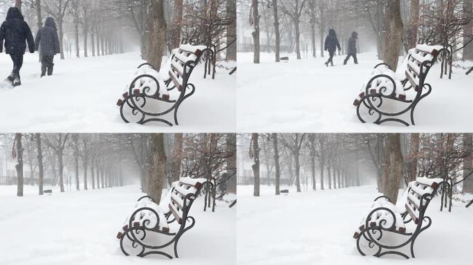 暴风雪中的冬季公园。长椅上覆盖着雪。